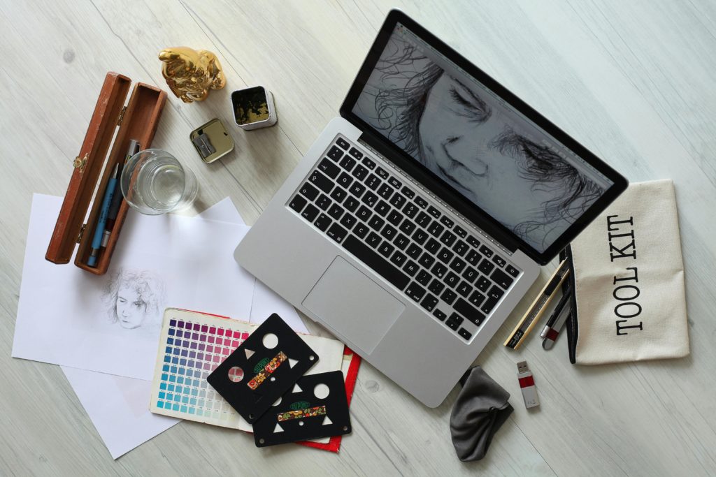 pexels-photo-414974-414974 Top view of a creative workspace with a laptop, sketch supplies, and color palette.